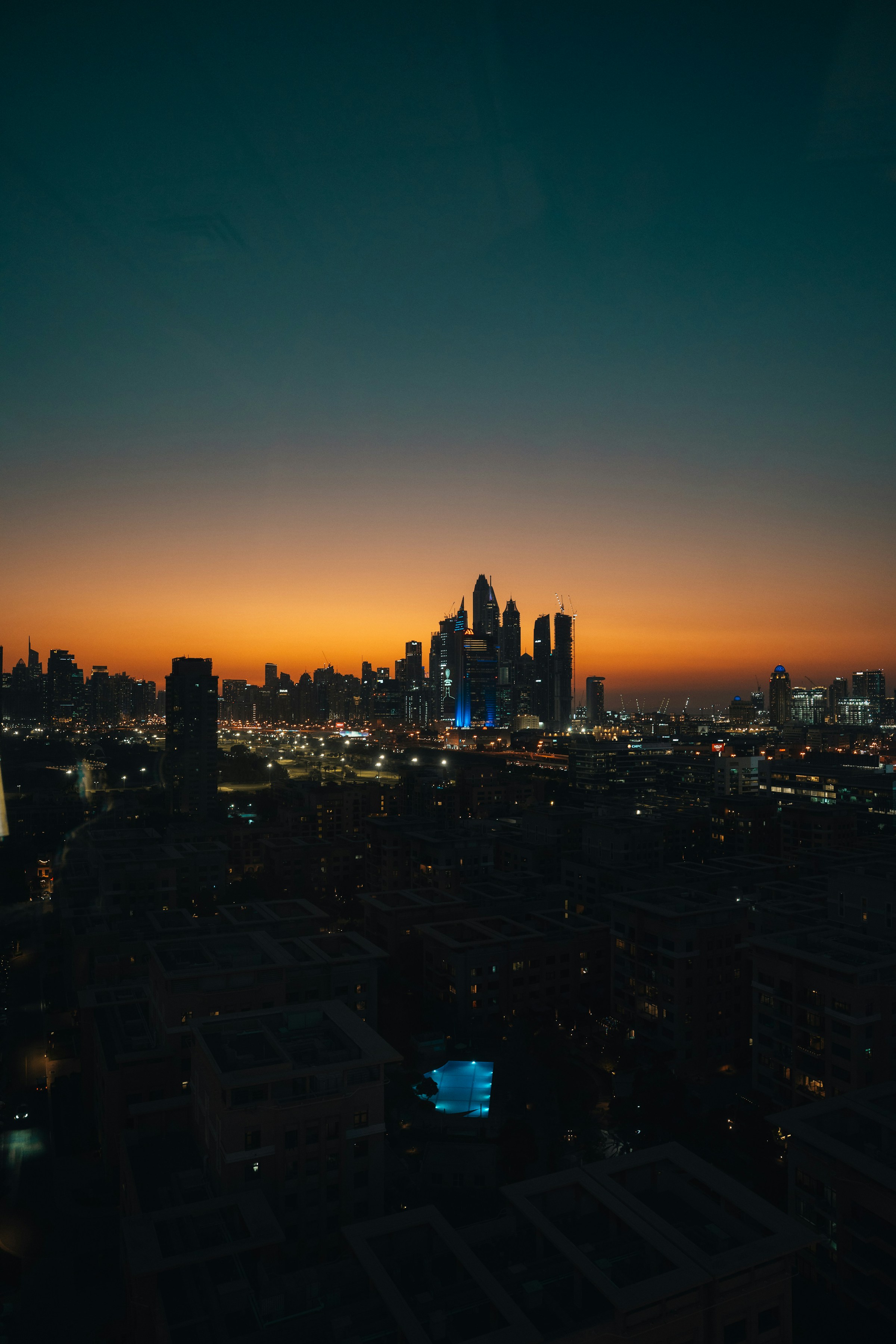 Dubai skyline and city lights beneath a warm sunset sky